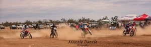 Five people riding dirt bikes on a track