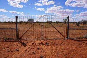 A private property fence with a sign that says wild dog barrier fence on it
