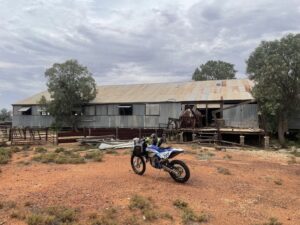 A motorbike in front of a shed