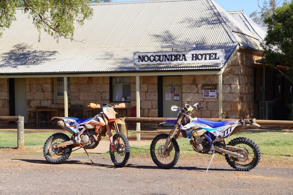 Two dirt bikes parked in front of the Noccundra Hotel
