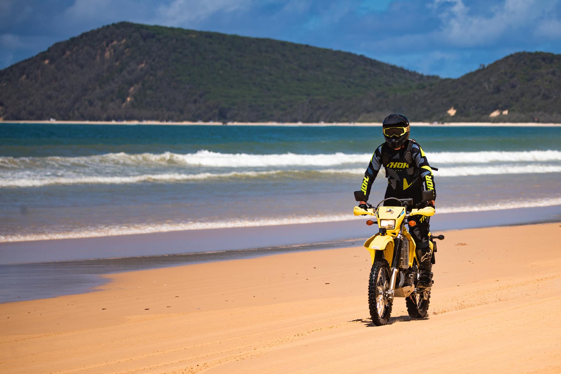 Person riding a dirt bike along the beach on the Sunshine Coast