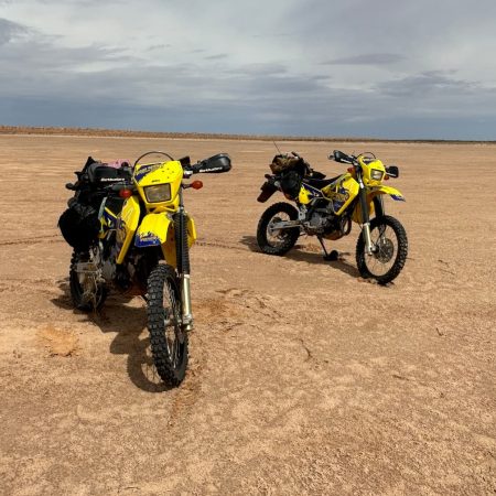 Two dirt bikes on a desert plain