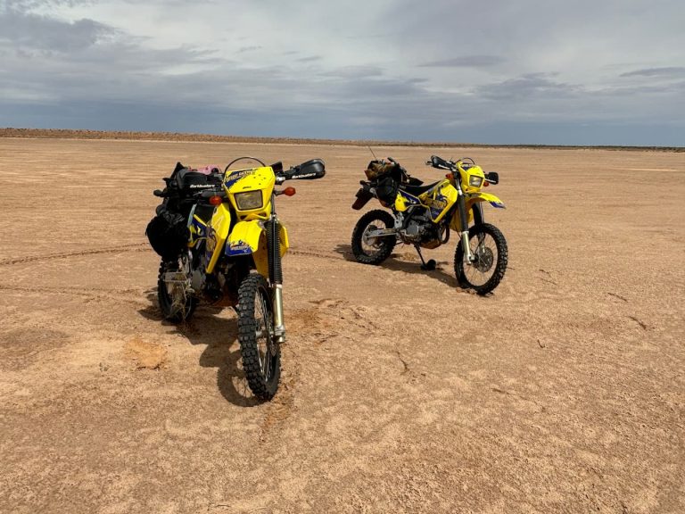 Two dirt bikes on a desert plain