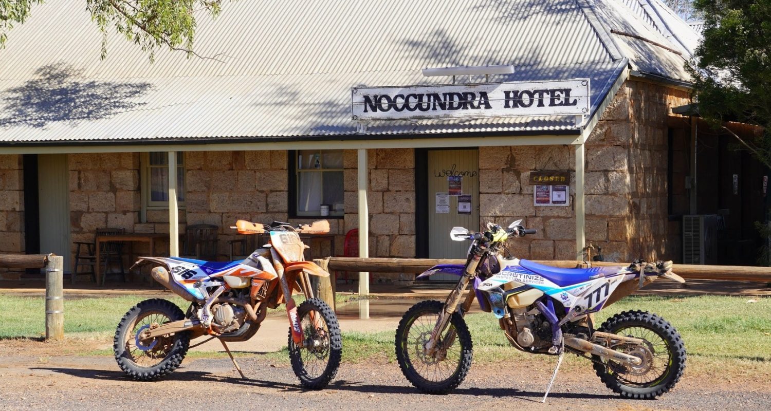 Two dirt bikes parked in front of the Noccundra Hotel